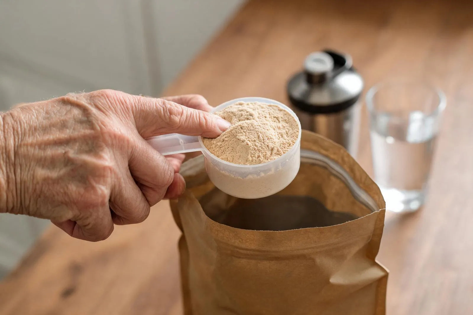 A scoop of protein over an open kraft pouch