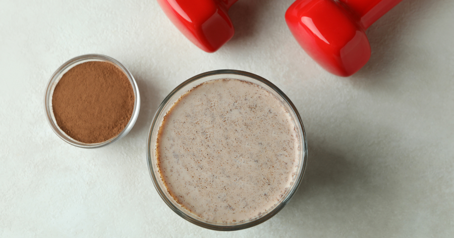 Dairy-free protein shake in a glass with simple clean ingredients on a white surface