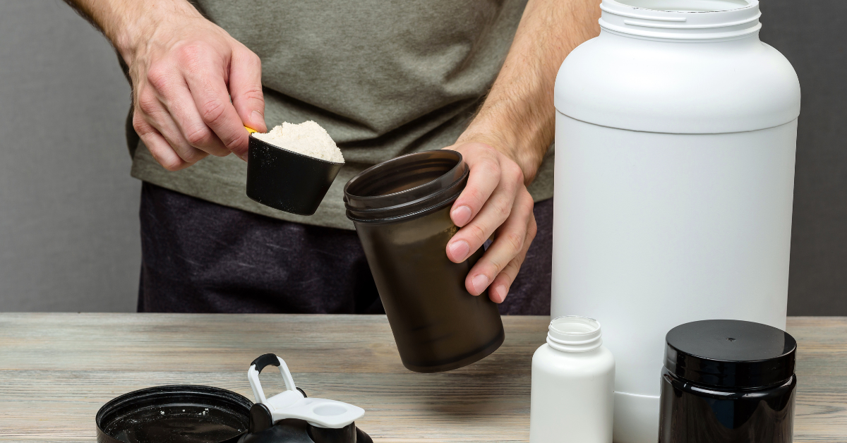 Fit person preparing a protein shake in a kitchen after a workout