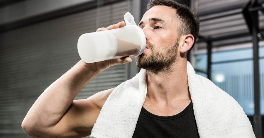 Person drinking a protein shake at the gym after a workout