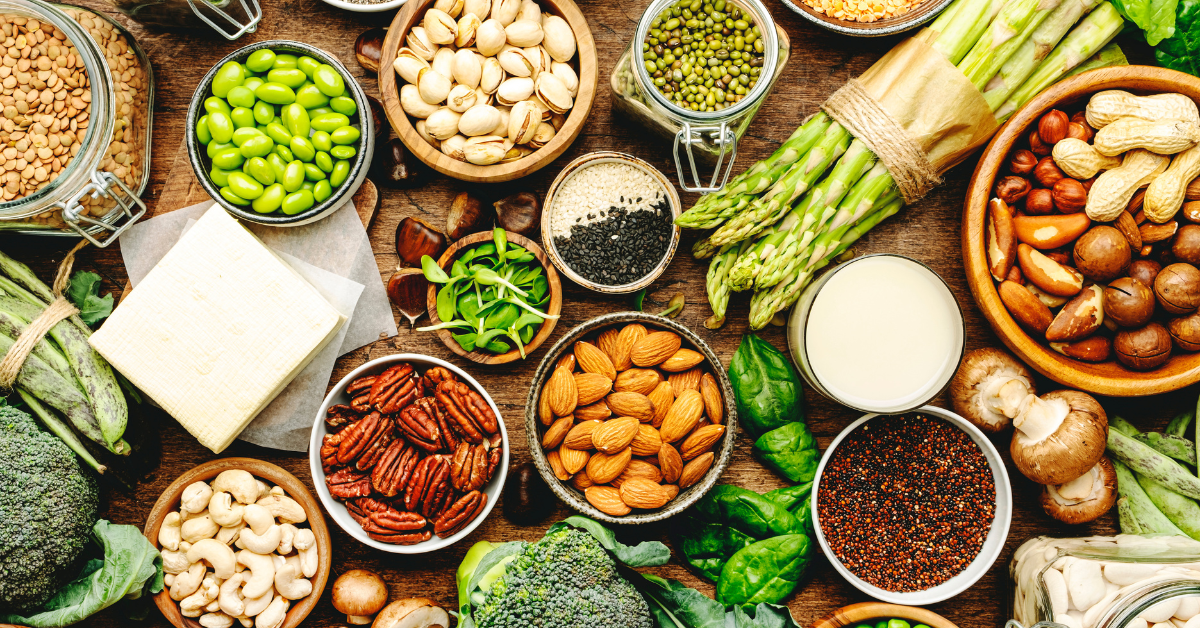 Variety of dairy-free protein sources including protein powder, nuts, and plant foods on a table