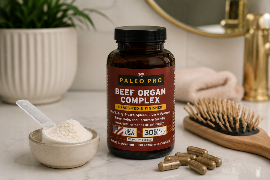 Beef organ supplement capsules and a scoop of collagen powder on a bathroom counter beside a hairbrush