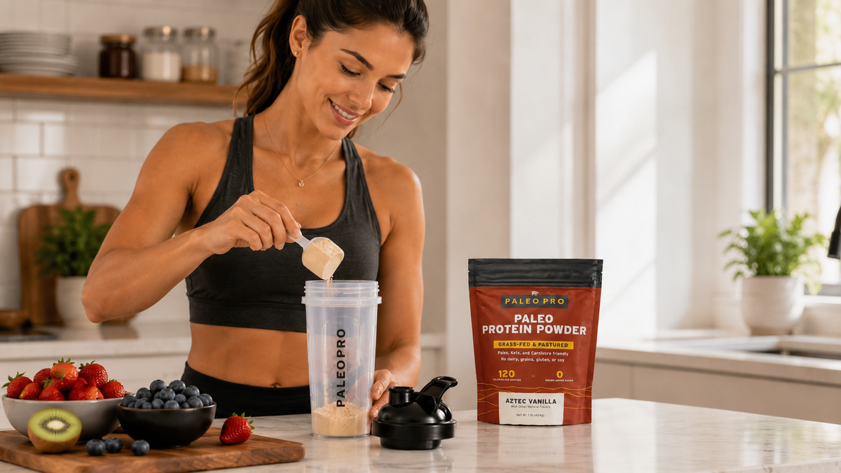 Woman scooping protein powder into a blender bottle on a kitchen counter with fresh fruit nearby